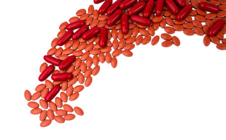 Red vitamins and supplements capsule and iron tablets isolated on white background with copy space and clipping path. Use for topics content about treatment anemia in adult and elderly peopleの写真素材