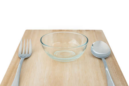 Wood cutting board and set of fork and spoon and small bowl for food, cereal or salads isolated on white background with clipping pathの写真素材