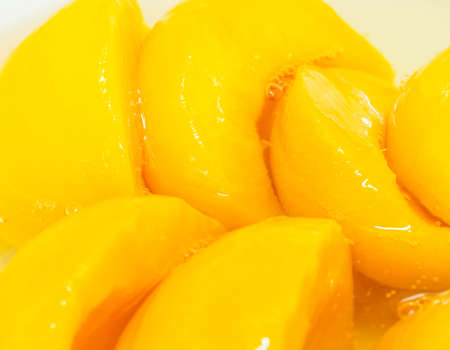 Closeup canned peach halves in syrupの写真素材