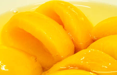 Closeup canned peach halves in syrupの写真素材