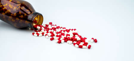 Colorful of antibiotic capsules pills with amber glass bottle on white background. Drug resistance, antibiotic drug use with reasonable, health policy and health insurance concept.の写真素材