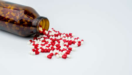Colorful of antibiotic capsules pills with amber glass bottle on white background. Drug resistance, antibiotic drug use with reasonable, health policy and health insurance concept.の写真素材