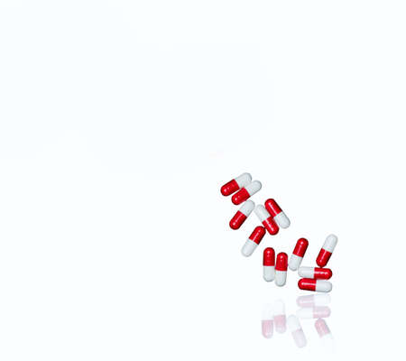 Red, white antibiotic capsules pills isolated on white background with copy space and clipping path. Drug resistance, antibiotic drug use with reasonable concept.の写真素材
