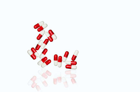 Red, white antibiotic capsules pills isolated on white background with copy space and clipping path. Drug resistance, antibiotic drug use with reasonable concept.の写真素材