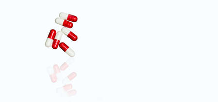 Red, white antibiotic capsules pills isolated on white background with copy space and clipping path. Drug resistance, antibiotic drug use with reasonable concept.の写真素材