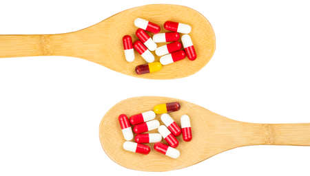 Colorful of antibiotics capsule pills in wooden spoon isolated on white background with copy space. Drug resistance concept. Antibiotics drug use with reasonable and global healthcare concept.の写真素材