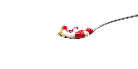 Antibiotic capsule pills in stainless steel spoon isolated on background with copy space. Drug resistance concept. Antibiotics drug use with reasonable and global healthcare concept.の写真素材