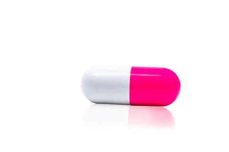 Pink, white capsule pills isolated on white background with shadow and copy space for text. Drug resistance concept. Antibiotics drug use with reasonable and global healthcare concept.の写真素材