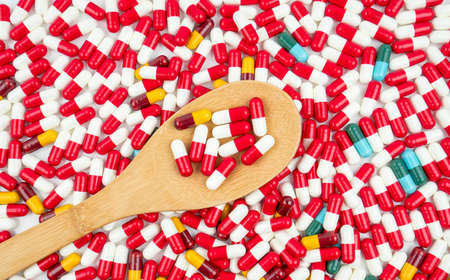 Colorful of antibiotic capsules pills and wood spoon on white background. Drug resistance concept. Antibiotics drug use with reasonable and global healthcare concept.の写真素材
