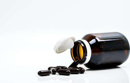 Multivitamins capsule pills for pregnant woman with amber bottle with blank label and copy space isolated on white background. Vitamins and supplements for hard working guy. Global healthcare conceptの写真素材