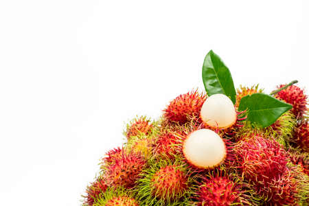 Closeup of fresh red ripe rambutan (Nephelium lappaceum) with leaves isolated on white background....