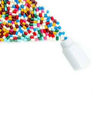 Antibiotic capsules spilling out of pill bottle on white background with copy space, just add your own text. Drug resistance concept. Antibiotics drug use with reasonable and global healthcare conceptの写真素材