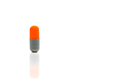 Orange, gray antibiotics capsule pill isolated on white background with copy space. Drug resistance concept. Antibiotics drug use with reasonable and global healthcare concept.の写真素材