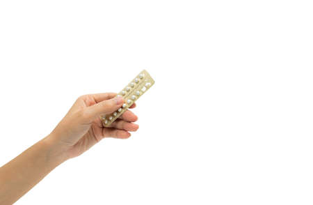 Woman hand taking birth control pills. Asian adult woman holding pack of contraceptive pills isolated on white background with clipping path. Choosing family planning with birth control pills conceptの写真素材