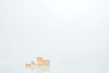 Five orange square tablets pills isolated on white background with shadows and copy space for text. Medical lozenges for relief cough, sore throat and throat irritation. Orange flavoredの写真素材