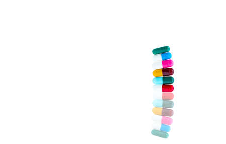 Antibiotic capsules pills in a row on white background with shadows and copy space. Drug resistance concept. Antibiotics drug use with reasonable and global healthcare concept.の写真素材