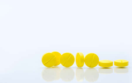 Yellow tablets pills isolated on white background with copy space. Pile of medicine.の写真素材
