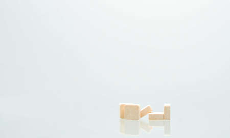Five orange square tablets pills isolated on white background with shadows and copy space for text. Medical lozenges for relief cough, sore throat and throat irritation. Orange flavoredの写真素材