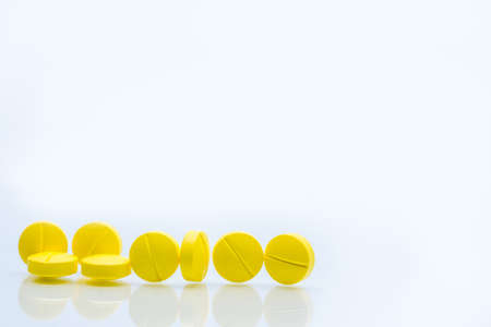 Yellow tablets pills isolated on white background with copy space. Pile of medicine. Painkiller tablets pills.の写真素材