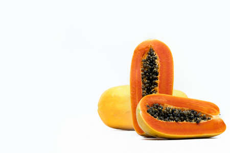Whole and half of ripe papaya fruit with seeds isolated on white background with copy space. Natural source of vitamin C, folate and minerals. Healthy food for pregnant and breast feeding womanの写真素材
