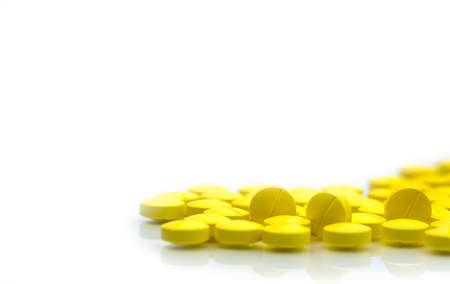 Yellow tablets pills isolated on white background with copy space. Pile of medicine. Painkiller tablets pills.の写真素材