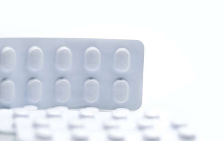Macro shot detail of tablets pill in white blister pack for light resistance packaging isolated on white background. Medicine for treatment NCDs. Elderly people disease.の写真素材