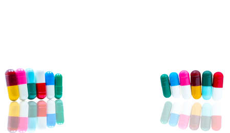 Antibiotic capsules pills in a row on white background with shadows and copy space. Drug resistance concept. Antibiotics drug use with reasonable and global healthcare concept.の写真素材