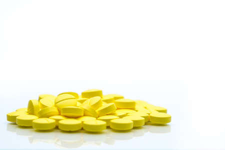 Yellow tablets pills isolated on white background with copy space. Pile of medicine. Painkiller tablets pills.の写真素材