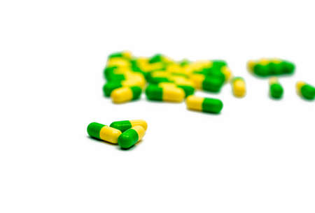 Green, yellow tramadol capsule pills on blurred capsule pills background with copy space. Cancer pain management. Opioid analgesics. Drug abuse in teenage.の写真素材