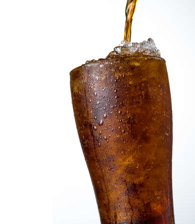 Soft drink with crushed ice cubes in glass isolated on dark background with copy space. There is a drop of water on the transparent glass surface.の写真素材