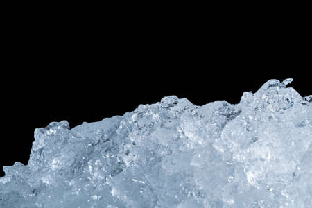 Pile of crushed ice cubes on dark background with copy space. Crushed ice cubes foreground for beverages, beer, whisky, fruit juice, milk, fresh food or fresh vegetables.の写真素材