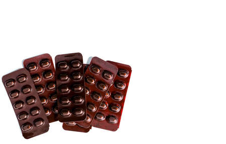Pile of tablets pills medicine in light resistant blister pack on white background . Vitamins and minerals tablets pills for pregnant women. Ferrous fumarate anemia treatment tablets pills.の写真素材