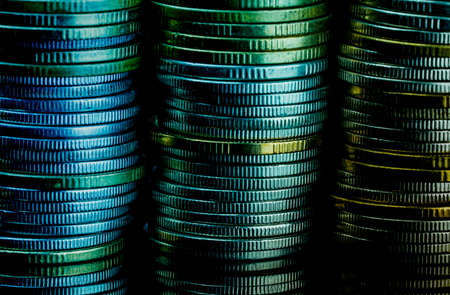 Macro shot detail of golden and silver color coin stacks on dark background with copy space for text. Business and finance growth, saving money, investment and interest concept.の写真素材