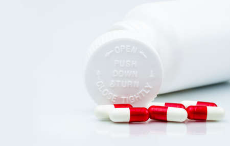 Capsules pills on white background and plastic bottle with blank label and copy space. Childproof packaging. Child resistant pill container. Push down and turn cap.Global healthcare and love concept.の写真素材