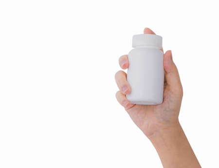 Woman's hand holding prescription pills bottle with blank label isolated on white background with copy space for text.の写真素材