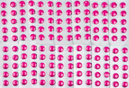 Full frame of round pink tablets pills in blister packs. Pink pills pattern use for love wallpaper. Ibuprofen tablets pills for relief pain, high fever, headache, toothache and wound inflammationの写真素材