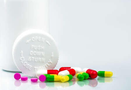 Colorful pills on white background and childproof bottle with blank label and copy space. Pharmacy department in the hospital concept. Drug store concept.の写真素材