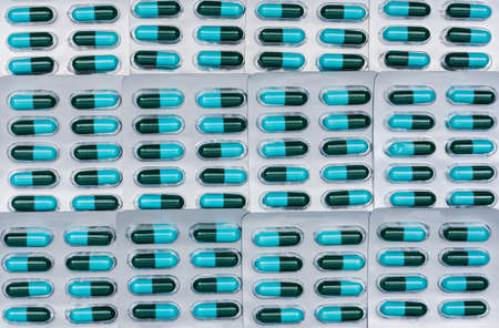 Full frame of blue and green antibiotics capsule pills in blister packs. Antimicrobial drug resistance and antibiotics drug use with reasonable concept. Amoxicillin ( Penicillin ) drug backdrop.の写真素材