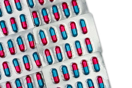 Colorful of blue, pink capsule with granule in side pills. Pills in blister pack on white background with space. Pharmaceutical dosage form and packaging. Anti-fungal medicine.の写真素材