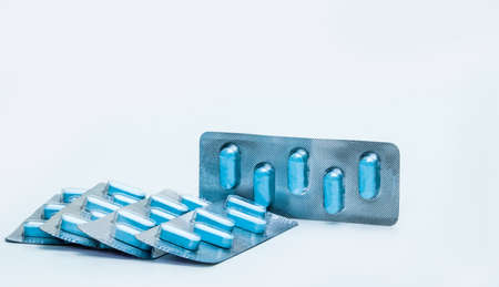 Macro shot of tablets pills in blister packs on white background. Five packs of antiviral medicine for treatment herpes viral infection. 5-day course of antivirals. Herpes virus concept.の写真素材
