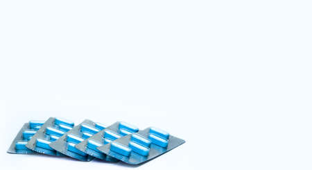 Macro shot of tablets pills in blister packs on white background. Five packs of antiviral medicine for treatment herpes viral infection. 5-day course of antivirals. Herpes virus concept.の写真素材
