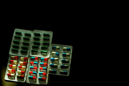Colorful of antibiotic capsule pills in blister pack on dark background with copy space. Medicine...