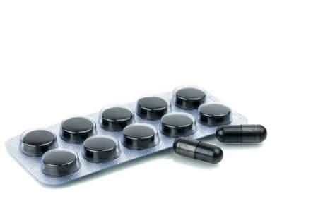 Capsules and tablets pills of activated charcoal in blister pack isolated on white backgroundの写真素材