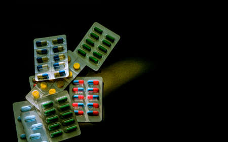 Colorful of antibiotic capsule pills in blister pack on dark background with copy space. Medicine for infections disease. Antibiotic drug use with reasonable. Drug resistance and healthcare concept.の写真素材