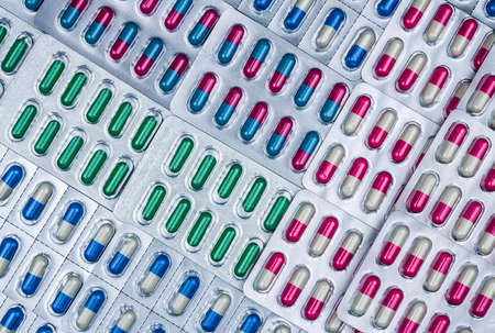 Full frame of colorful capsule pills in blister pack arranged with beautiful pattern. Pharmaceutical packaging. Medicine for infections disease. Antibiotic drug use with reasonable. Drug resistance.の写真素材