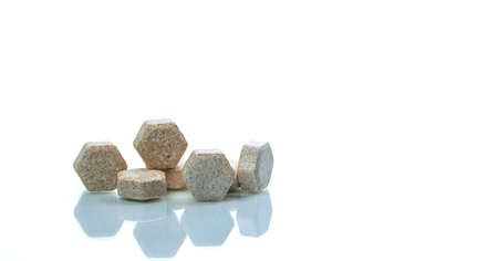 Macro shot detail of brown hexagon medical lozenges with Brazilian green propolis extract for relief cough, sore throat and throat irritation on white background with copy space. Lozenges tabletsの写真素材