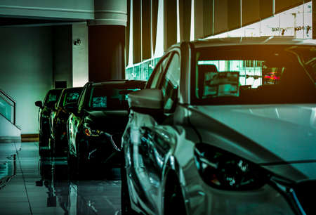 Closeup new luxury compact car parked in modern showroom for sale. Car dealership office. Car retail...