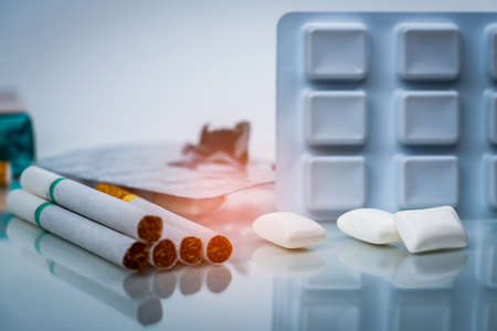 Nicotine chewing gum in blister pack near pile of cigarette. Quit smoking or smoking cessation and lung cancer concept. 31 May : World no tobacco day.の写真素材