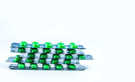 Stacks of green round sugar-coated tablet pills in blister packs on white background with copy space. Pharmaceutical marketing. Pharmaceutical industry. Dextromethorphan : medicine for dry coughの写真素材