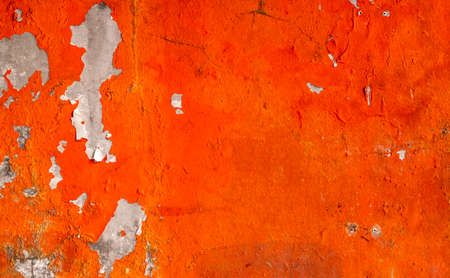 Orange color painted on concrete wall are peeling. Old and dirty wall texture background with space.の写真素材